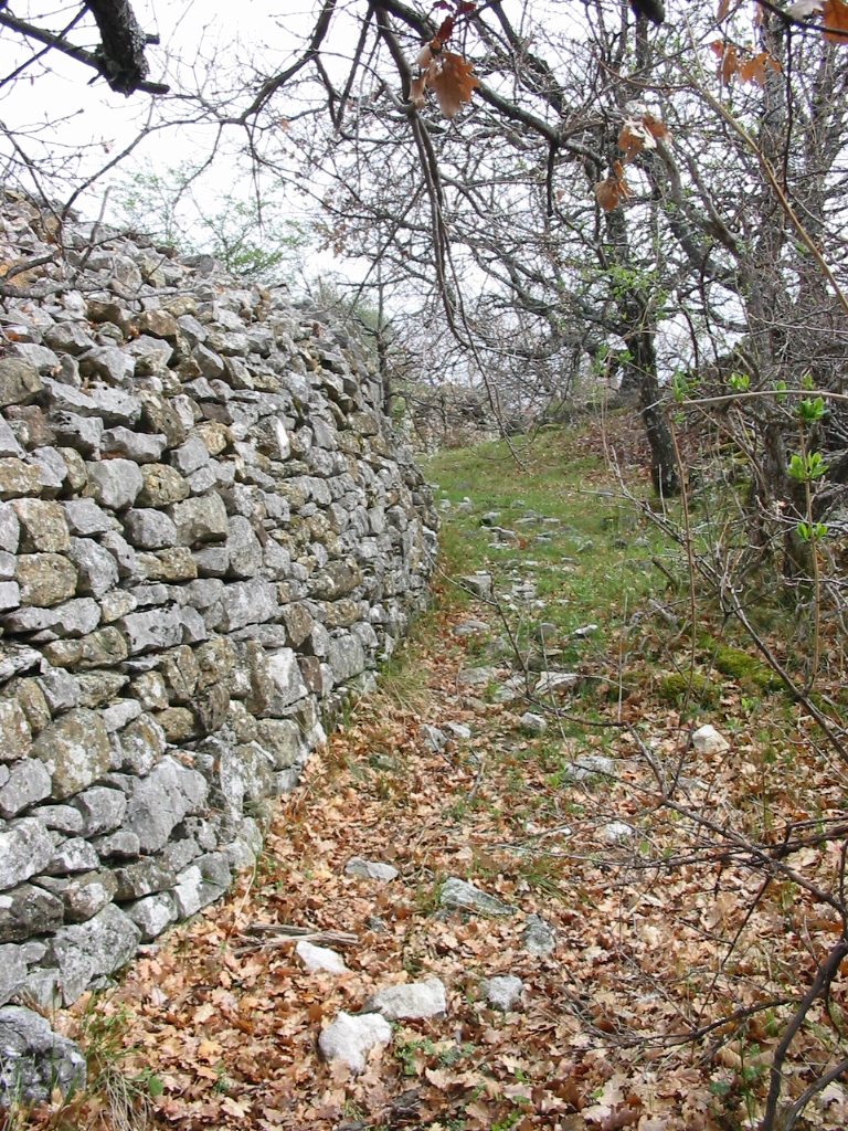 Une rue longeant un mur du hameau.
